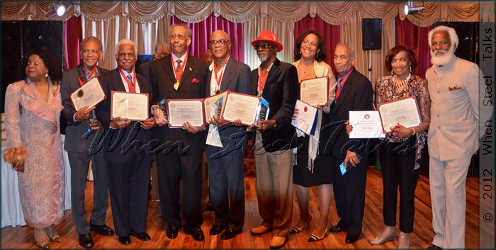 Honored Steelband pioneers and proxies hold awards at the end of the evening