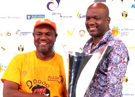 Hells Gate Steel Orchestra band member receives 2019 Panorama Championship trophy from Antigua & Barbuda's Minister for Minister of Sports, Culture, National Festivals, and the Arts - Daryll Matthew