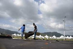 getting ready: Workmen lay out ground cover yesterday, in preparation for Sunday’s annual Panorama semi-finals on The Greens, at the Queen’s Park Savannah, Port of Spain, ahead of today’s inspection by Pan Trinbago officials