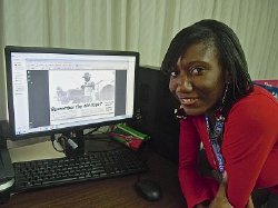 Student research assistant Aniya Teneille Carty with computer screen of clipping.
