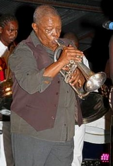 South African trumpeter Hugh Masekela performs in the Siparia Deltones panyard last Saturday during the launch of the collaborative between the band and the musician