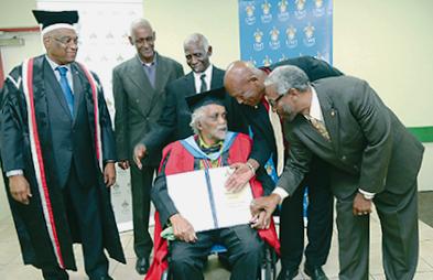 Pan Trinbago president Keith Diaz, second right, and secretary Richard Forteau, right, congratulate Anthony Williams after he was awarded an Honorary Doctor of Letters (DLitt), from the University of the West Indies, at a graduation ceremony hosted by the St Augustine Campus of the UWI on October 22. At left, is Prof Brian Copeland, pro vice-chancellor and campus principal, UWI St Augustine.