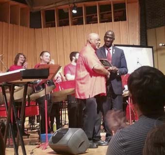 The Hon. Anthony Phillips-Spencer, Ambassador of the Republic of Trinidad and Tobago to the U.S., presents an award to Cliff Alexis at the tribute concert Sunday.