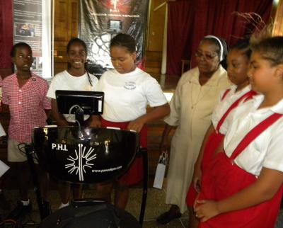 Principal Sister Annetta Alexander looks on as a student plays the instrument for the first time