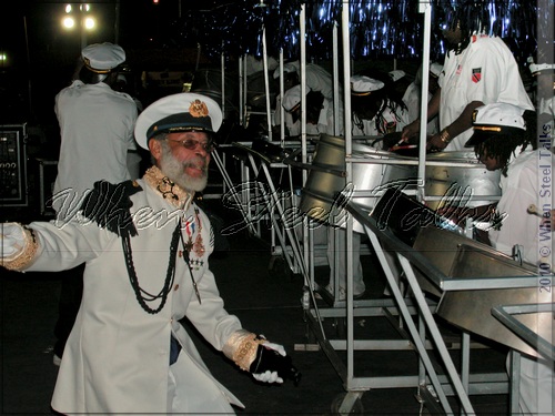 Late master musician and arranger Clive Bradley with Pantonic Steel Orchestra in iconic 2002 photo on stage