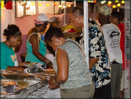 Hostess Sherma Thomas (left) sees to guests at the Caribbean Food Fest