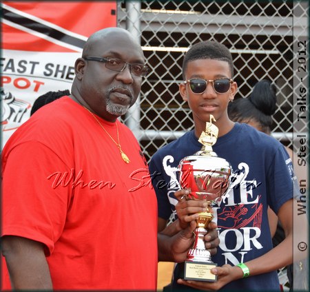 Bomb Tune Competition winner ADLIB Steel Orchestras representative receives prize trophy from USSA president Keith Marcelle
