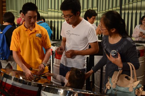 A member of the Ensemble talks about the steelpan with attendees
