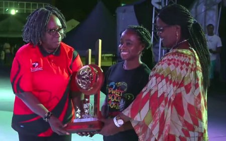 Pan Trinbago president Beverley Ramsey-Moore (left) and St. Lucia National Steelbands Association president Perline Mathurin (right), present the Pantime Steel Orchestra representative (center) with the trophy for second place