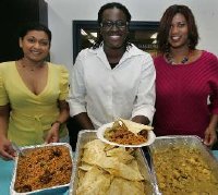 Alicia Holford and colleagues with Trinidadian food prepared for University of Akron Steel Drum Band members