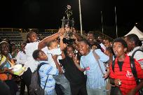 Members of T&TEC Tropical Angel Harps Youth Steel Orchestra hoist the championship trophy in the non-school category at Mondays National Junior Steelband Music Festival