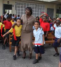 Diego Martin Boys RC School teacher Stella Richards Alleyne dances with pupils at yesterday’s launch of the National Junior Panorama
