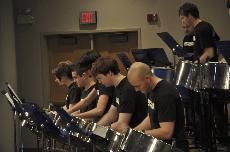 Several students from the ensemble play lead pan drums during the performance