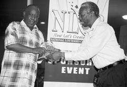 Nigel Flemming, left, accepts the Young Arranger Award on behalf of his son Nathaniel, from Richard Forteau, secretary of Pan Trinbago.
