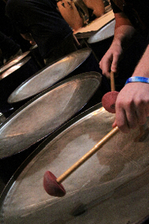 Playing a bass pan in a steel band