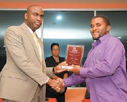 Deputy Mayor of Port-of-Spain Kerron Valentine, left, presents Kern Lopez with an award for best young arranger at Pan Trinbagos Northern Region Carnival 2014 prize-giving ceremony at the Grand Stand, Queens Park Savannah, on Friday night.