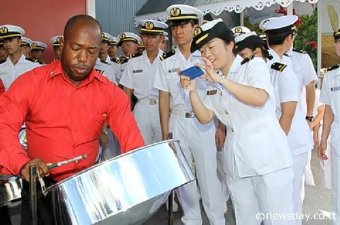 SOUVENIR PHOTO: A sailor from the Japanese vessel 'Kashima' takes a photo of Private Jason Holder of the Defence Force Steel Orchestra who played to welcome sailors of three Japanese vessels which arrived yesterday at the port in Port-of-Spain for a three-day visit