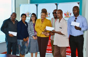 Pan Trinbago East Zone chairman Carlon Harewood collected the cheques from Culture Minister Dr Nyan Gadsby- Dolly (center), at Nicholas Tower, Independence Square, Port of Spain.