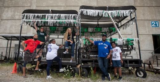 Wendy Jones and a few members of the Pan Fantasy steel pan band pose outside of their 'pan yard,' the rehearsal space where they practice and arrange their performances for Toronto Caribbean Carnival