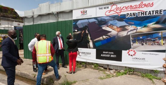 UdeCOTT chairman Noel Garcia, second from right, and employees look at the Desperadoes Pan Theatre billboard before the sod-turning ceremony to start the construction at Nelson Street, Port-of-Spain, yesterday