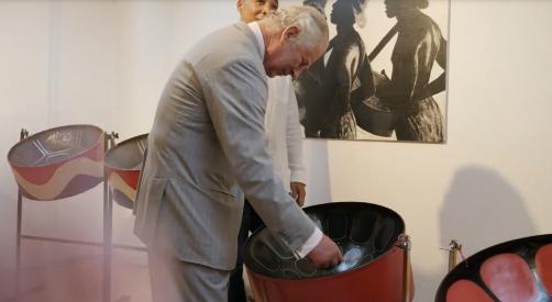 Prince Charles tries his hand at steelpan while Notting Hill Carnival Ltd. Executive Director Matthew Phillip looks on