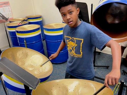 A Marathon student practices on the steel drums.