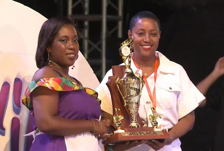 Krystal Nestor (left ) arranger for Pantastic Muzik Steel Orchestra, receives the third-place trophy from Tamara Gibson (right)